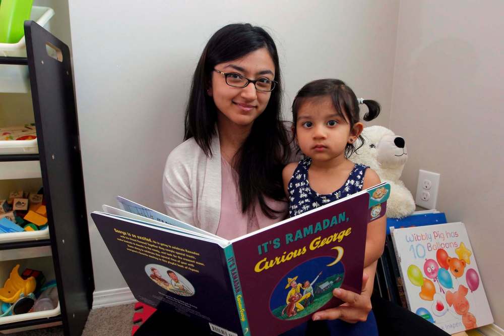 BORIS MINKEVICH / WINNIPEG FREE PRESS
Mother Taj Shakir-Farooqui and her daughter Zoya, 2, read the new Curious George book It's Ramadan, Curious George, which employs the familiar children's book character to help explain the rituals of Islam's holiest month.