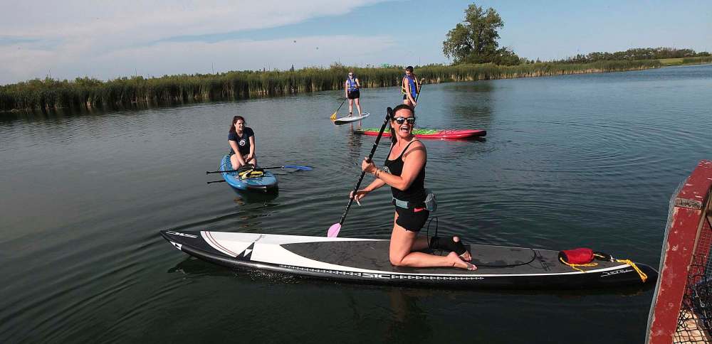 PHIL HOSSACK / WINNIPEG FREE PRESS
Paddle Canada instructor Dayna Fryza (front) sets out with a class of novices last week. Devotees to paddleboarding say once a beginner finds out how easy the sport is, it’s instant love.