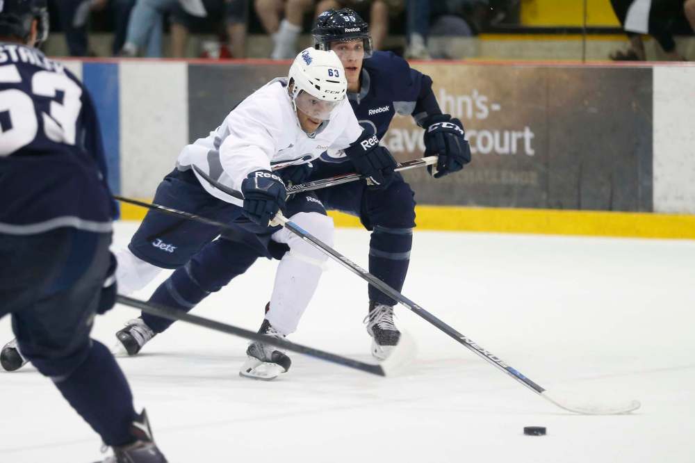 JOHN WOODS / WINNIPEG FREE PRESS
Team Blue Alec McCrea (95) tries to hold back Team White Erik Foley (63) during development camp at the Iceplex Tuesday.