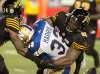Peter Power
/ The Canadian Press
Winnipeg Blue Bombers running back Andrew Harris (33) is tackled by Hamilton Tiger-Cats Drake Nevis (91) and Travis Lee (14) during the second half of CFL football action in Hamilton on Thursday, July 7, 2016.
