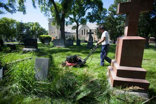 RUTH BONNEVILLE / WINNIPEG FREE PRESS
Groundskeeper Dennis Beaulieu works his way around the headstones and uneven ground to mow the lawn at the historic cemetery near St. John’s Anglican Cathedral in Winnipeg.