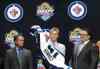 AP Photo / Alan Diaz 
Kyle Connor, center, puts on a Winnipeg Jets sweater after being chosen 17th overall during the first round of the NHL hockey draft, Friday, June 26, 2015, in Sunrise, Fla.