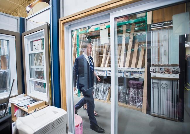 Federal Conservative leader Andrew Scheer is pictured through glass windows as he arrives to make a campaign stop in Jonquiere, Que., on Wednesday, September 25, 2019. THE CANADIAN PRESS/Nathan Denette