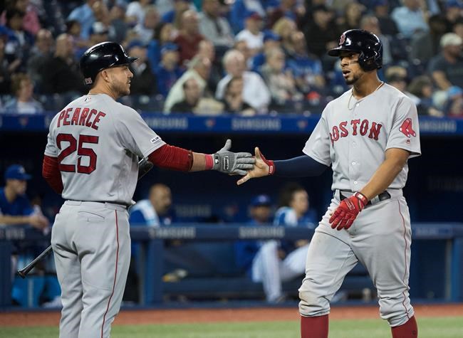 Boston Red Sox's Xander Bogaerts, right, celebrates his scored run with teammate Steve Pearce (25) during sixth inning American League MLB baseball action in Toronto on Thursday, May 23, 2019. THE CANADIAN PRESS/Nathan Denette