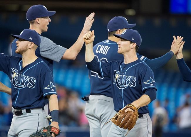 Tampa Bay Rays second baseman Joey Wendle, right, celebrates with teammates after driving in the game winning run during ninth inning American League MLB baseball action against the Toronto Blue Jays, in Toronto on Sunday, July 28, 2019. THE CANADIAN PRESS/Nathan Denette