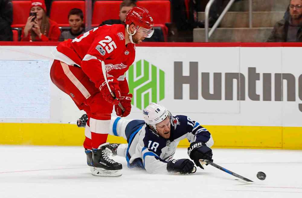(AP Photo/Paul Sancya)
Winnipeg Jets center Bryan Little tries to pass from the ice as Detroit Red Wings defenseman Mike Green defends in the third period of an NHL hockey game Tuesday in Detroit.