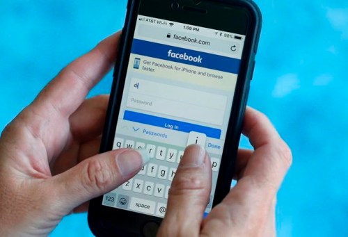 FILE - In this Aug. 21, 2018 file photo, a Facebook start page is shown on a smartphone in Surfside, Fla. A growing number of people say they are deleting Facebook, or at least considering it. Before you take the plunge, remember to download your data, then, you can deactivate temporarily, or delete everything in a few steps. (AP Photo/Wilfredo Lee, File)