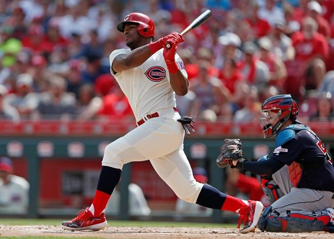 FILE - In this July 6, 2019, file photo, Cincinnati Reds' Yasiel Puig, left, follows through on a two-run home run off Cleveland Indians starting pitcher Shane Bieber during the first inning of a baseball game, in Cincinnati. The Indians bulked up for the playoff race by trading temperamental starter Trevor Bauer before the deadline to Cincinnati in a three-team deal they hope can help them run down the Minnesota Twins. Cleveland, which trails the AL Central by three games but leads the wild-card race, sent Bauer to the Reds for slugger Yasiel Puig and left-hander Scott Moss. The Indians also acquired outfielder Franmil Reyes, lefty Logan Allen and infield prospect Victor Nova from the San Diego Padres, who acquired outfielder Taylor Trammel from the Reds.(AP Photo/Gary Landers, File)