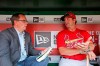 FILE - In this May 27, 2016, file photo, St. Louis Post Dispatch writer Derrick Goold, left, talks with St. Louis Cardinals manager Mike Matheny before a baseball game against the Washington Nationals at Nationals Park, in Washington. A videographer who collapsed from a heart attack in the visiting dugout at Busch Stadium is alive, thanks in part to a St. Louis Post-Dispatch journalist. The videographer, 64-year-old Mike Flanary, was in the Chicago Cubs' dugout Sunday, Sept. 29, 2019, before the game the Cardinals eventually won 9-0 to clinch the National League Central title. Flanary collapsed and was briefly without a pulse. The Post-Dispatch reports that baseball writer Derrick Goold had CPR training as a youth and rushed to help. The stadium doctor on duty, David Tan, says Goold's CPR 