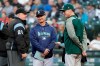 FILE - In this May 1, 2018, file photo, umpire Bill Miller, left, talks with Seattle Mariners manager Scott Servais, center, and Oakland Athletics manager Bob Melvin before a baseball game, in Seattle. (AP Photo/Elaine Thompson, File)