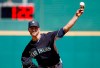 FILE - In this March 8, 2015, file photo, Seattle Mariners' J.A. Happ throws a pitch between innings as pitch clock counts down in the background during a spring training baseball game against the Cincinnati Reds in Goodyear, Ariz. Major League Baseball and its players are discussing bold changes to spark the sport that include a three-batter minimum before a pitching change except at the start of an inning, a single trade deadline set before the All-Star break and expanding rosters. (AP Photo/Ross D. Franklin, File)