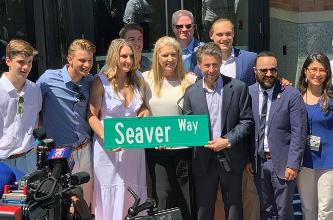 Anne Seaver, third from left, and her sister, Sarah Seaver, daughters of former New York Mets pitcher Tom Seaver, hold a street sign with New York Mets owner Jeff Wilpon, third from right, outside Citi Field in New York, Thursday, June 27, 2019. Others are unidentified. Tom Seaver is getting a statue outside the Mets' home, and the team is getting a new address. The announcement was made official at a ceremony Thursday. Citi Field will now be listed as 41 Seaver Way in honor of the Hall of Fame pitcher's number. New York City officials agreed to the team's request to rename the 126th Street address.(AP Photo/Avery Yang)