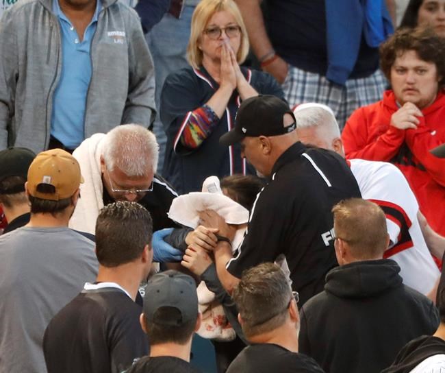 FILE - In this Monday, June 10, 2019, file photo, Emergency personal keep a towel on the face of a person who was struck by a line drive by Chicago White Sox's Eloy Jimenez during the fourth inning of a baseball game against the Washington Nationals in Chicago. The Chicago White Sox plan to extend the protective netting all the way to the foul poles at Guaranteed Rate Field, becoming the first major league team to take such a step in the wake of a couple of high-profile fan injuries. (AP Photo/Charles Rex Arbogast, File)