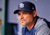 FILE - In this Aug. 23, 2018, file photo, Tampa Bay Rays manager Kevin Cash sits in the dugout before a baseball game against the Kansas City Royals, in St. Petersburg, Fla. Cash's team was one of the feel-good stories of 2018, improving by 10 victories despite undergoing a massive makeover that purged salary and ignited a youth-driven, second-half turnaround that kept Tampa Bay in contention for a postseason berth until late September. (AP Photo/Steve Nesius, File)