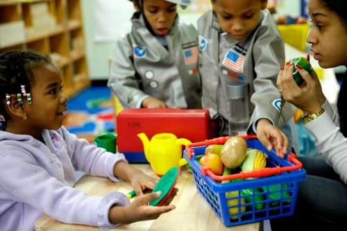 FILE - In this Tuesday, Jan. 21, 2014 file photo, Oumou Balde, 4, left, plays with her teacher Jacqualine Sanchez, right, and some pretend food in a pre-kindergarten class at the Sheltering Arms Learning Center in New York in a program that was produced in conjunction with the Sesame Street children's television show to educate children about nutrition and health. Lead author of a analysis released on Tuesday, May 21, 2019, Dr. Amanda Perak, a heart specialist at Chicago's Lurie Children's Hospital, says in most cases, kids can improve cholesterol levels by adopting healthier habits _ eating more fruits, vegetables, whole grains and less processed food, and exercising more. (AP Photo/Seth Wenig)