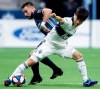 FILE - In this April 5, 2019, file photo, Vancouver Whitecaps' Inbeom Hwang, right, and Los Angeles Galaxy's Romain Alessandrini vie for the ball during the first half of an MLS soccer game in Vancouver, British Columbia. Alessandrini will be sidelined until September after undergoing his third knee surgery. The Galaxy announced Friday, April 26, 2019, that Alessandrini needed meniscus root repair in his left knee after getting hurt two weeks ago. (Darryl Dyck/The Canadian Press via AP, File)