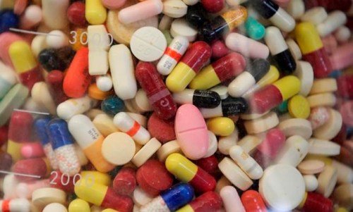 FILE - This July 6, 2017 file photo shows prescription drugs in a glass flask at the state crime lab in Taylorsville, Utah. A report released on Wednesday, March 13, 2019 says pills can contain ingredients like gluten, lactose or allergy-triggering dyes that may cause problems for certain patients. (AP Photo/Rick Bowmer, File)