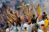 FILE - In this July 7, 2019, file photo, U.S. player Megan Rapinoe holds the trophy after winning the Women's World Cup final soccer match against The Netherlands at the Stade de Lyon in Decines, outside Lyon, France. Rapinoe is enjoying the whirlwind of a two-time World Cup winner. She picked up the FIFA Player of the Year award in Milan rocking a deeper shade of lavender hair, sent off retiring U.S. coach Jill Ellis with an undefeated victory tour and kept up the fight for pay equity against the U.S. Soccer Federation. (AP Photo/Claude Paris, File)