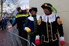 FILE - In this Nov. 18, 2017, file photo, Black Petes and police officers leave after the arrival of Sinterklaas, or Saint Nicholas in Dokkum, northern Netherlands. Confrontations broke in the Netherlands over supporters and opponents of the divisive helper of the Dutch version of Santa Claus. The helper, known as Black Pete, is played by whites in blackface at children‚Äôs events. (AP Photo/Peter Dejong, File)
