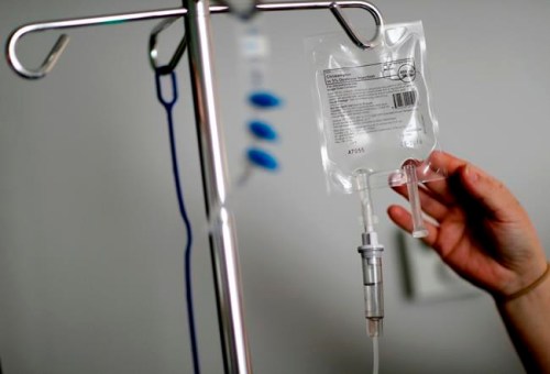 FILE - In this Feb. 9, 2018, file photo, a nurse hooks up an IV to a flu patient at Upson Regional Medical Center in Thomaston, Ga. Adults in their late 20s and 30s face medical collections at a higher frequency than older Americans, a study finds, possibly due to lower incomes, lower insurance rates and insurance with high shared costs. (AP Photo/David Goldman, File)