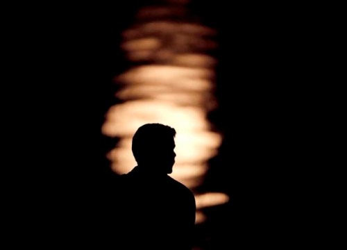 FILE- In this June 27, 2018, file photo a man is silhouetted against moonlight reflecting off the Missouri River as he watches the full moon rise beyond downtown buildings in Kansas City, Mo. Change is constant, especially when you‚Äôre young. Chances are you‚Äôll cycle through a few moves, job changes and romantic relationships as you establish your life as a young adult. (AP Photo/Charlie Riedel, File)