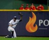 FILE - In this Sept. 18, 2018 file photo, Milwaukee Brewers' Curtis Granderson raises his glove after making a sliding catch in the outfield during the fifth inning of a baseball game against the Cincinnati Reds in Milwaukee. Granderson has agreed to a minor league contract with the Miami Marlins and will report to big league spring training. If added to the 40-man roster, he would get a one-year contract that pays $1.75 million while in the major leagues and have the chance to earn $250,000 in performance bonuses for plate appearances. (AP Photo/Aaron Gash, File)