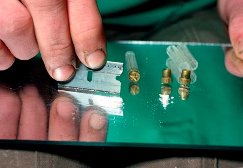FILE - In this 1989 file photo, a razor blade is used to divide the contents of a five-dollar vile of crack, a smokable, purified form of cocaine, at a crack house in the South Bronx section of New York. Cocaine deaths have been rising, health officials said Thursday, May 2, 2019, in their latest report on the nation‚Äôs drug overdose epidemic. After several years of decline, overdose deaths involving cocaine began rising in 2013. And they jumped by more than a third between 2016 and 2017. (AP Photo/Mark Lennihan, File)