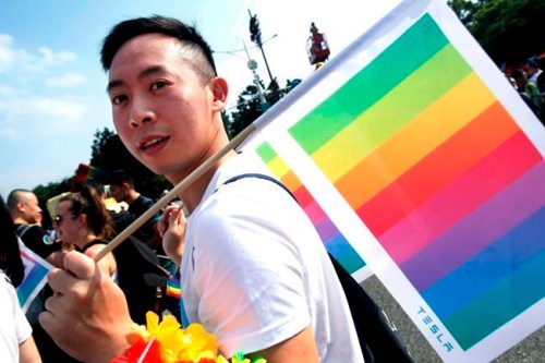 FILE - In this Oct. 27, 2018 file photo, a participant carries the rainbow flag during the annual gay and lesbian parade, organized by Taiwan LGBT Pride, in Taipei, Taiwan. This time of year can be tough for LGBTQ children and teens when it comes to gatherings. And advocates believe there's even more at stake when shifts in identity, new names and pronouns, unsupportive relatives and a general lack of knowledge about related gender issues are in play, particularly for the first time. (AP Photo/Chiang Ying-ying, File)