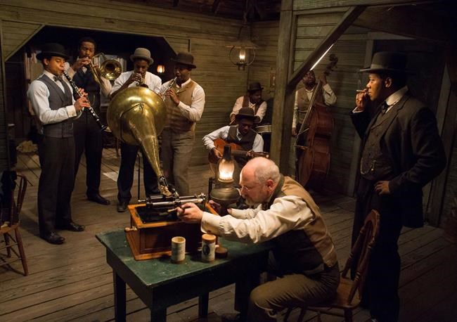 This image released by Abramorama shows, background from left, Robert Ri’chard, Ser’Darius Blain, Gary Carr, Calvin Johnson, Donald Watkins, Justin Faulkner, Korey Webb-Turner, Keith Flippen, foreground center, and Erik LaRay Harvey, foreground right, in a scene from