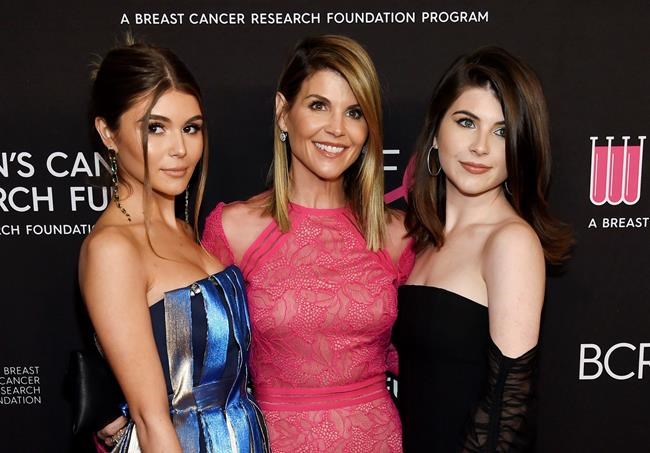 FILE - In this Feb. 28, 2019 file photo, actress Lori Loughlin, center, poses with daughters Olivia Jade Giannulli, left, and Isabella Rose Giannulli at the 2019