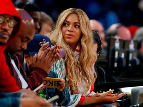 FILE - In this Feb. 19, 2017. file photo, Beyonce sits at court side during the second half of the NBA All-Star basketball game in New Orleans. The pop star said on Thursday, April 4, 2019, she is on board as a creative partner for Adidas, and she will develop new footwear and apparel for the brand. Beyonce is also planning to re-launch her activewear clothing line, Ivy Park, with Adidas. (AP Photo/Max Becherer, File)