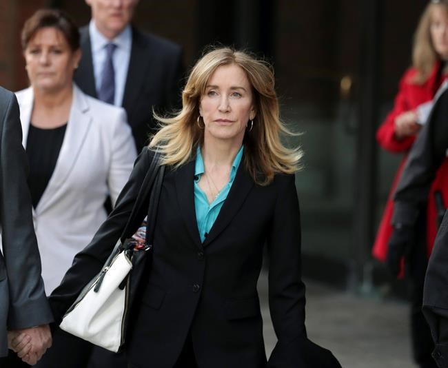 FILE - This April 3, 2019 file photo shows actress Felicity Huffman departing federal court in Boston after facing charges in a nationwide college admissions bribery scandal. Federal prosecutors are asking a judge to sentence “Desperate Housewives” star Felicity Huffman to a month in jail for her role in the sweeping college admissions bribery scandal. (AP Photos/Charles Krupa, File)