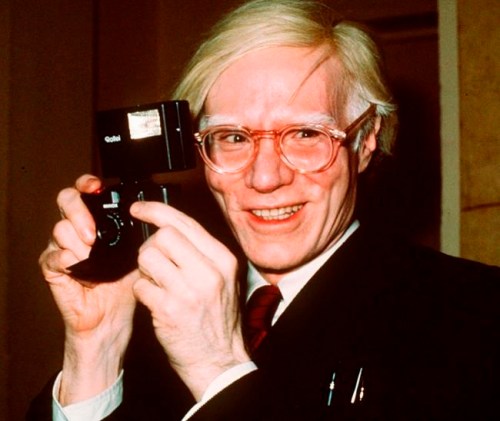FILE - In this 1976 file photo, pop artist Andy Warhol holds a camera in New York. A new exhibition titled, 