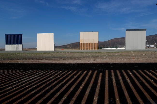 FILE - In this Wednesday, Dec. 12, 2018, file photo, border wall prototypes stand in San Diego near the Mexico-U.S. border, seen from Tijuana, Mexico, where the current wall casts a shadow in the foreground. (AP Photo/Moises Castillo, File)