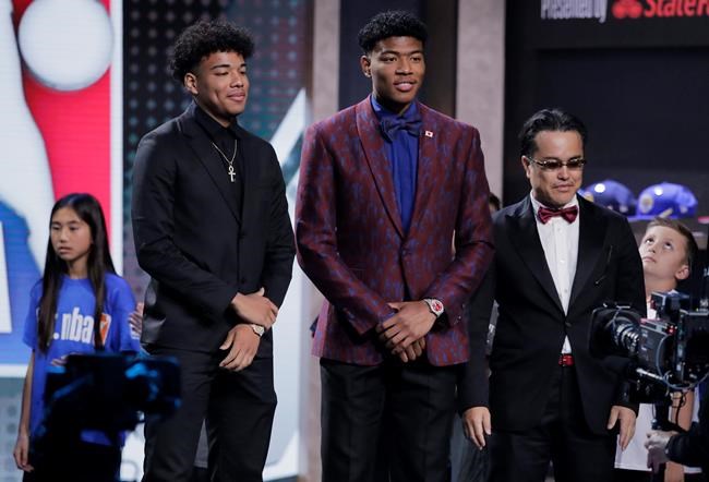 Japan's Rui Hachimura, center, of Gonzaga, poses for photographs with loved ones as he is introduced during the NBA basketball draft Thursday, June 20, 2019, in New York. (AP Photo/Julio Cortez)