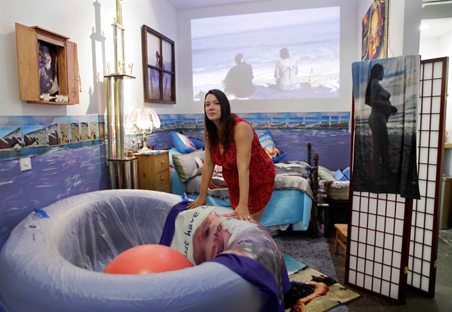 Brooklyn-based performance artist Marni Kotak, who plans to give birth to her first child in front of a public audience at the Microscope Gallery in the Bushwick section of Brooklyn, is shown leaning on a birthing pool at the gallery, which has been converted into a birthing room, in New York, Monday, Oct. 17, 2011. The birth will be assisted by a midwife. (AP Photo/Kathy Willens)