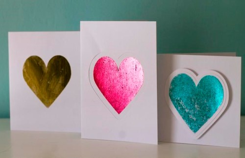 This photo taken Jan. 27, 2019 shows valentine cards made in Hopkinton, N.H. Adding foil to greeting cards can turn the simplest shape into something more fancy. These cards shown here were made by applying colored foil three different ways. The gold heart was made using double-sided adhesive, the pink heart was made using a laser printer and laminating machine and the blue heart was made using a a stencil and spray adhesive. (AP Photo/Holly Ramer)