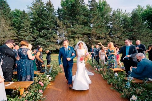 This June 16, 2018 photo provided by Beth Helmstetter Events/The Good Beginning shows Sarah and Matthew Schimenti during their wedding ceremony at Winvian Farm in Morris, Conn. Initially, the couple intended to tell wedding guests they did not wish to receive any gifts for their wedding, but decided to use their happy occasion to help a favorite charity. Using The Good Beginning, a registry for couples seeking charitable donations in lieu of gifts, the Schimentis solicited donations for The Carver Foundation, which provides youth programming in Morris, Conn. (Steve Steinhardt/Beth Helmstetter Events/The Good Beginning via AP)