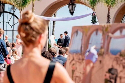 This 2018 photo shows artist Laura Swytak painting during a wedding ceremony at Fess Parker in Santa Barbara, Calif. Some couples are inviting painters to capture a scene or the mood of their big day in a work they can cherish. Having the artist at the reception also adds a special kind of entertainment. (Matt Roberts/Rewind Photography/Laura Swytak via AP)