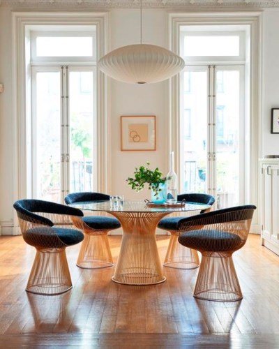 This photo provided by Knoll Furniture shows the company's glass-topped dining table set. Knoll Furniture is marking the100th anniversary of the Bauhaus school by re-imagining some iconic pieces like Warren Platner's 1966 glass topped dining table, now with a rose gold wire base, shown here. Knoll also has new finishes for designs by Breuer, van der Rohe and Bertoia. Fresh takes on classic design looks modern now. (Knoll Furniture via AP)