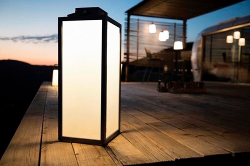 This photo provided by Les Jardins shows solar outdoor lights. The light reinterprets the classic lantern design with a slim, teak-framed portable light that has a solar module producing LED light for up to 200 hours per charge. There's a motion sensor and dimming capability as well. Solar lights are a great way to illuminate a porch when electrical plugs aren't possible or practical. (Les Jardins Solar Lighting via AP)