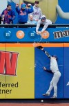 A fan spills beer on Milwaukee Brewers left fielder Ryan Braun as he tries but fails to grab a triple hit by New York Mets' Pete Alonso during the first inning of the MLB baseball game at Citi Field, Sunday, April 28, 2019, in New York. (AP Photo/Seth Wenig)
