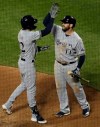 Milwaukee Brewers' Christian Yelich, left, is greeted at home plate by Mike Moustakas after hitting a solo home run off New York Mets starting pitcher Noah Syndergaard during the fourth inning of a baseball game, Saturday, April 27, 2019, in New York. (AP Photo/Julio Cortez)