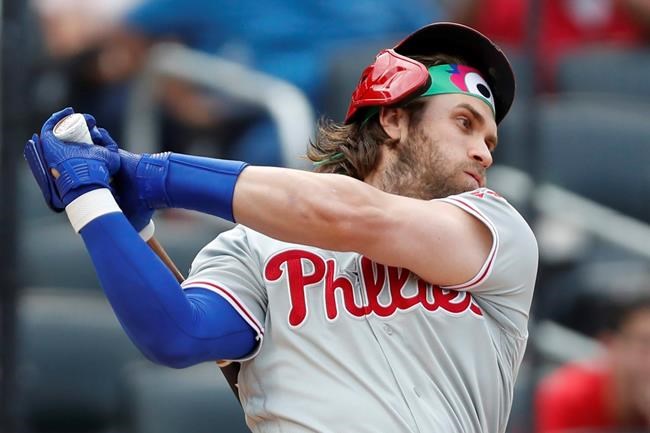 Philadelphia Phillies pinch hitter Bryce Harper loses his helmet as he swings at a pitch during the seventh inning of a baseball game against the New York Mets, Sunday, Sept. 8, 2019, in New York. (AP Photo/Kathy Willens)