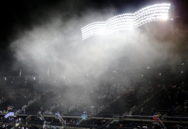 Fans watch the Miami Marlins play the New York Mets in the rain during the eighth inning of a baseball game Saturday, May 11, 2019, in New York. The Mets won 4-1. (AP Photo/Frank Franklin II)