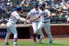New York Mets' Michael Conforto, left, reaches out to Robinson Cano, right, and Pete Alonso, center, after they scored on a double by Todd Frazier against the San Diego Padres in the first inning of a baseball game, Thursday, July 25, 2019 in New York. (AP Photo/Mark Lennihan)