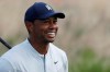 Tiger Woods smiles after teeing off on the 12th hole in the Northern Trust tournament at Liberty National Golf Course, Thursday, Aug. 8, 2019, in Jersey City, N.J. (AP Photo/Mark Lennihan)