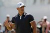 Brooks Koepka acknowledges applause after putting on the first hole of the final round in the Northern Trust golf tournament at Liberty National Golf Course, Sunday, Aug. 11, 2019 in Jersey City, N.J. (AP Photo/Mark Lennihan)