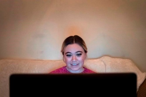 In this Jan. 14, 2019 photo, Caitlin Powers sits in the living room of her Brooklyn apartment in New York, and has a telemedicine video conference with physician, Dr. Deborah Mulligan. Widespread smartphone use, looser regulations and employer enthusiasm are helping to expand access to telemedicine, where patients interact with doctors and nurses from afar, often through a secure video connection. (AP Photo/Mark Lennihan)