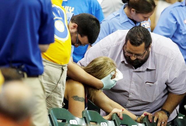 FILE - In this July 6, 2015, file photo, a fan is helped after being hit by a foul ball during the ninth inning of a baseball game between the Milwaukee Brewers and the Atlanta Braves in Milwaukee. Illinois' two senators have urged Major League Baseball to be more transparent about fans who are injured by foul balls, saying the lack of data is creating confusion about the extent of the problem. Democratic Sens. Dick Durbin and Tammy Duckworth said in a letter to baseball Commissioner Rob Manfred this week that MLB should